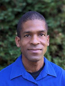 Picture of black man wearing blue shirt.